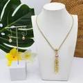 Détail du collier à tube doré et boucles d'oreilles créoles avec perles roses sur fond tropical - Style Perle Rose Clair (HWNX9703-2)