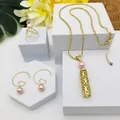 Détail d'un ensemble de bijoux dorés avec perles roses, pendentifs creux et boucles - Style Perle Rose (HWNX9703-6)