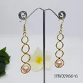 Hammered gold circles drop earrings with pink pearl charms hanging on silver stand - Pink