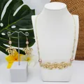Vue détaillée du collier tortue dorée hawaïenne et boucles d'oreilles perles roses - Ton Rose avec Perle