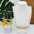 Parure de bijoux de style île avec motif tortue évidé et perles roses sur décor tropical - Style Perle Rose Clair