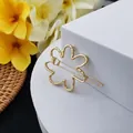 Vue détaillée d'une pince à cheveux fleurie dorée sur un support d'exposition blanc - Style Fleur Ajouré (B-003-14)