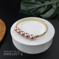 Macro detail of engraved copper bangle with pink pearls on a tropical display stand - Pink Style (HWB1057-2)