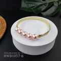 Dettaglio di bracciale dorato con perle rosa e motivi floreali incisi su un piedistallo - Stile Rosa Acceso (HWB1057-6)