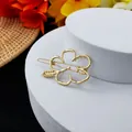 Detailed close-up of a hollow gold hibiscus flower hair clip on a white pedestal - Hollow Hibiscus Style (B-003-2)