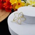 Détail d'une pince à cheveux fleur dorée évidée sur socle blanc avec décor floral - Style Fleur Élégante à Cinq Pétales (B-003-4)