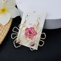 Detail of hollow monstera leaf earrings with brown shell pearls on Aloha display card - Brown Pearl Style (HWX693-9)