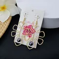 Detailed shot of hollow tropical leaf earrings with iridescent purple beads on card - Deep Purple Bead Style (HWX693-1)