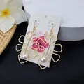 Detail of hollow monstera leaf earrings with white pearls on a tropical Aloha display card - White Pearl Style (HWX693-4)