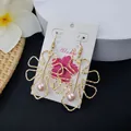 Gold hollow leaf earrings with pink pearl drop on Aloha display card with flowers - Pink Bead Style (HWX693-6)