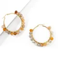 Macro detail of large gold hoop earrings with colorful natural stone beads wrapping - Labradorite