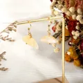 Detail of handmade gold wire-wrapped earrings with irregular raw yellow quartz stones - Topaz