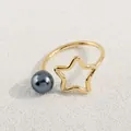 Nahaufnahme eines minimalistischen Sternrings mit grauer Perle auf einer goldenen Schiene - Gold Graue Perle Stern Stil (AWM_8165)