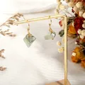 Natural light green raw stone earrings with gold stainless steel hooks on display - Prehnite