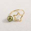 Makroaufnahme minimalistischer Ring mit hohlem Stern und olivgrüner Perle im Detail - Gold Grüne Perle Stern Stil (AWM_8168)
