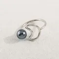Details des minimalistischen Mondrings mit grauer Perle auf beigem Hintergrund - Silber Graue Perle Mond Stil (AWM_8178)