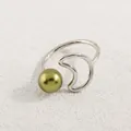 Detail eines verstellbaren Silbermondsrings mit olivgrüner Perle auf Texturhintergrund - Silber Grüne Perle Mond Stil (AWM_8179)