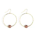 Detail von goldenen Creolen mit Hammerschlag-Textur und brauner Perle im minimalistischen Stil - Gold Und Kaffeebraune Perle