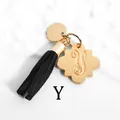 Detail of gold petal charm with engraved letter y and black tassel on marble surface - Letter Y-Gold Tassel