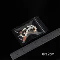 Blumenperlenarmband mit rotem Anhänger im 8x12cm dicken transparenten PE-Druckverschlussbeutel - Kleiner Stil
