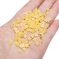 Hand holding pale yellow resin flower beads for DIY jewelry and earring making - 5mm (20 Pieces/Pack) / Yellow