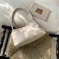 Sac à main élégant en cuir tressé crème avec bandoulière assortie sur une chaise - Blanc