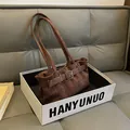 Bolso retro de ante marrón oscuro con hebilla plateada en una caja de exhibición - Marrón