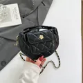 Schwarze gesteppte Handtasche aus Kunstleder mit goldener Kamelie und Kettenriemen - Schwarz