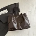 Dark brown high-gloss leather tote bag with pleated side details and gold chain handles - Brown