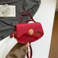 Red contrast material handbag with gold ring lock and glossy patent leather finish - Red