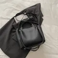 Bolso cubo minimalista negro con textura lichi y detalles metálicos dorados - Negro