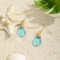Detail of handmade wire-wrapped sea glass earrings on a beach sand background - Light Blue (HWG280-3)