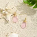 Detail of pink teardrop sea glass earrings with gold wire wrap on white beach sand - Pink (HWG280-4)