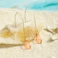 Handmade wire-wrapped sea glass drop earrings in peach on a white sandy beach background - Peach Pink (HWG016-1)