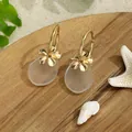 Detail of sea glass teardrop earring with golden flower on a beach scene tray - Transparent White Style (HWG018-2)