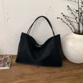 Bolso tote minimalista de ante negro con asas largas en un ambiente de alta calidad - Negro sin Colgante