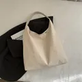 Borsa tote minimalista in pelle PU bianco crema con tracolla larga su sfondo moderno - Bianco