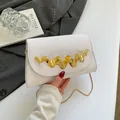 Moderne weiße Umhängetasche mit gewellter Goldverzierung und eleganter Kette - Flap Clutch Stil / Weiß