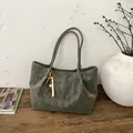 Sac fourre-tout en daim vert avec pompon rétro sur un banc en bois, style minimaliste - Avec Pendentif / Vert