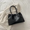 Grand sac cabas noir en similicuir avec boucle dorée présenté sur un tissu beige chic - Sans Pendentif / Noir