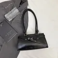 Minimalistische schwarze Kunstleder-Quadrat-Schultertasche mit Silberschnalle im Lifestyle - Schwarz