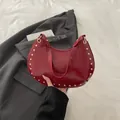 Chic burgundy crescent shoulder bag in glossy patent leather with gold stud details - Red