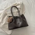 Sac cabas en cuir marron foncé avec breloque ours sur fond de blazer blanc - Avec pendentif ours / Marron