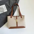 Elegante bolso tote de lona beige con ribete de cuero marrón y cierre metálico - Marrón