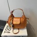 Sac à bandoulière demi-lune marron avec poignée réglable et pompon décoratif - Avec Pendentif / Marron
