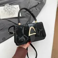 Minimalist black flap crossbody bag with gold hardware and elegant textured finish - Black
