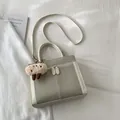 Retro-Shopper aus Wildleder in Taupe mit weißem Besatz und süßem Bären-Anhänger - Mit Anhänger / Weiß
