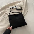 Minimalistische schwarze Wildleder-Beuteltasche mit Knotengurt und Prägung auf der Front - Schwarz
