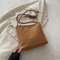 Braune Beuteltasche aus Wildlederimitat mit Fashion-Prägung und geknotetem Schultergurt - Braun