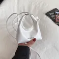 Mini white crossbody dumpling bag in glossy patent leather with hollow handle - White